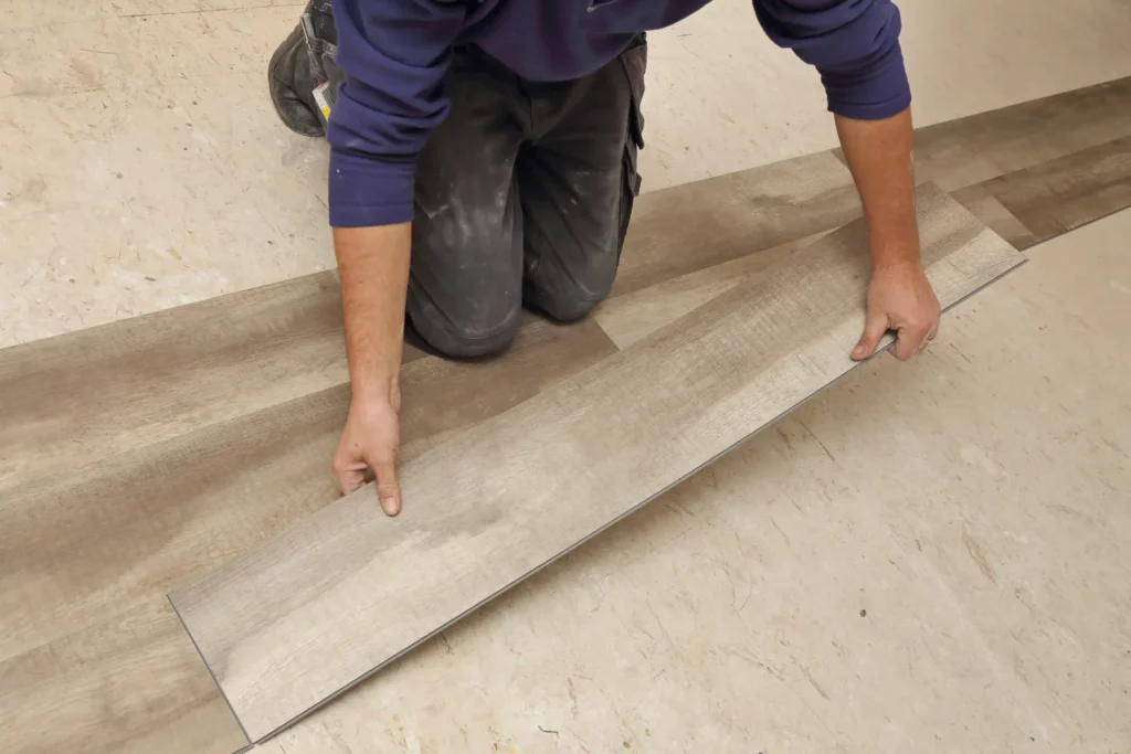 Homme posant un plancher.